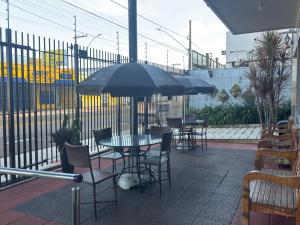 a table and chairs with an umbrella on a patio at Hotel Flor de Minas in Uberaba
