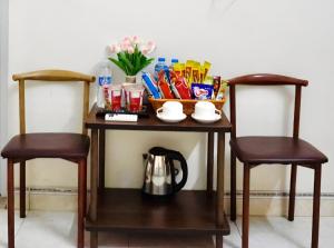a table with a tea kettle and two chairs at Nhà nghỉ Việt Mến in Sầm Sơn