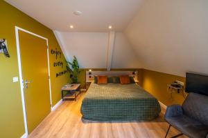 a bedroom with a bed and a couch at Hotel Onder De Linden in Roden