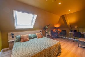 a bedroom with a bed with a window above it at Hotel Onder De Linden in Roden