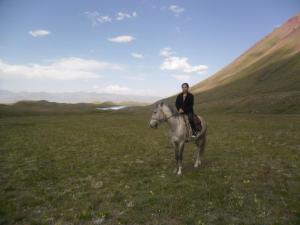 a person riding a horse in a field at Nice Hostel in Sary-Mogul