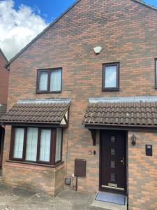 a brick house with a black door and windows at The Wigmore house in Luton