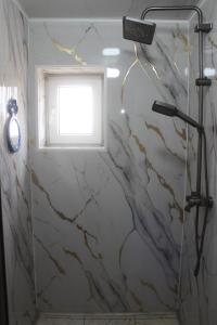 a bathroom with a marble shower with a window at Nice Hostel in Sary-Mogul +43 photos