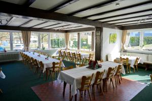 a room with white tables and chairs and windows at Gasthof ALTE POST-Schwarzwald Plus gratis in Waldachtal