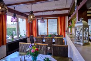 a restaurant with a table and chairs and windows at Gasthof ALTE POST-Schwarzwald Plus gratis in Waldachtal