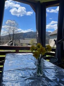 a table with a vase with yellow flowers on it at Sosnova hilka in Mykulychyn