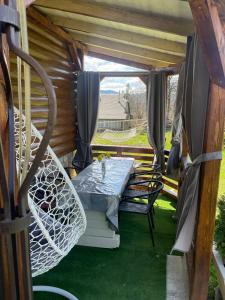 a patio with a table and chairs on a porch at Sosnova hilka in Mykulychyn
