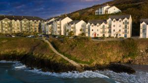 a row of houses on a hill next to a river at 2 bed Beachfront Apartment Inchydoney Cork in Cork