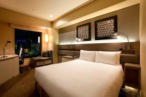 a bedroom with a large white bed and a window at The Royal Park Hotel Iconic Tokyo Shiodome in Tokyo