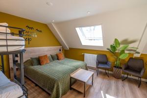 a bedroom with a bed and two chairs and a window at Hotel Onder De Linden in Roden +87 photos