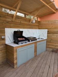 a outdoor kitchen with a grill on a wooden deck at Villa Irabo in Albenga