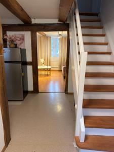 a staircase leading to a kitchen with a refrigerator at Rooms4Rent in Bottmingen +1 photo