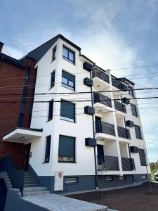 a white building with balconies on the side of it at Jefimija Apartman Sokobanja in Soko Banja