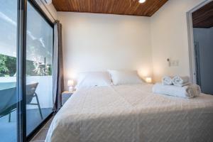 a bedroom with a large bed with two towels on it at Mango Coliving Apartments for Digital Nomads in Uvita +18 photos