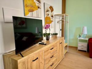 a television on a wooden dresser in a living room at Sweet Simo House in Azzate