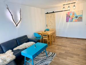 a living room with a blue couch and a table at Maria Altreichenau in Neureichenau