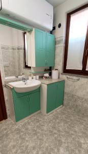 a bathroom with green cabinets and a sink at Sweet Simo House in Azzate