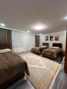 a bedroom with two beds and a rug at Gusar bungalow in Qusar