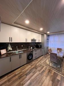 a kitchen with white cabinets and a table and a dining room at Gusar bungalow in Qusar +36 photos