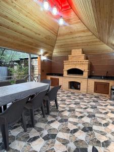 a large patio with a table and a fireplace at Gusar bungalow in Qusar