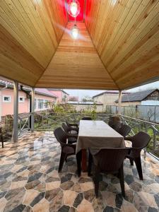 a patio with a table and chairs under a wooden ceiling at Gusar bungalow in Qusar