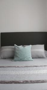 a bed with two pillows and a green and white pillow at Casa Barbeiro in Pombal +59 photos
