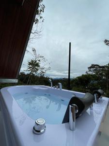 a bath tub with a sink with a view at Refugio de la niebla puyo glamping in Puyo +4 photos