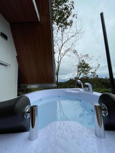 a bath tub with a view of a tree at Refugio de la niebla puyo glamping in Puyo