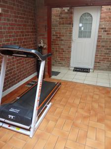 a treadmill in front of a brick building with a door at Appartement Neuf Raismes in Raismes +2 photos