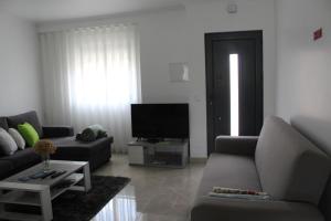 a living room with a couch and a tv at Casa Barbeiro in Pombal