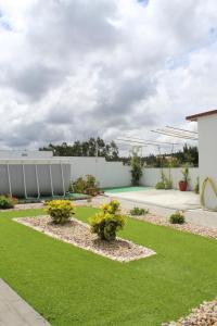 a garden with grass and bushes and a building at Casa Barbeiro in Pombal
