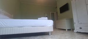a bedroom with a white bed and a tv at Penthouse in the historical center with sea view 5 minutes away,400mt, from main square in Amalfi