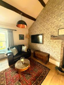 a living room with a couch and a table at Burnlee House Apartment in Holmfirth