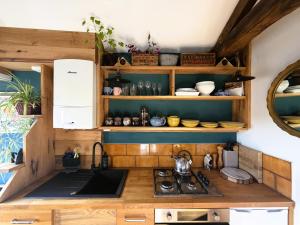 a kitchen with a sink and a stove in a room at Burnlee House Apartment in Holmfirth