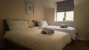 a bedroom with two beds with towels on them at 2 bed Beachfront Apartment Inchydoney Cork in Cork