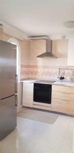 a kitchen with a stainless steel refrigerator and a stove at Apartamento Pargue Tropical in Los Cristianos