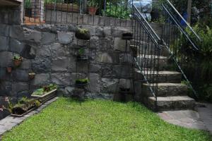 a stone retaining wall with stairs and potted plants at Loft São Joaquim in São Joaquim