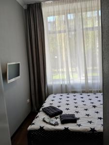 a bed in a bedroom with a window with towels on it at Optimal in Vyshneve