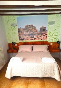 a bedroom with a bed with a painting on the wall at Pensión Isasa in Arnedo