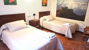 a hotel room with two beds and a painting on the wall at Pensión Isasa in Arnedo
