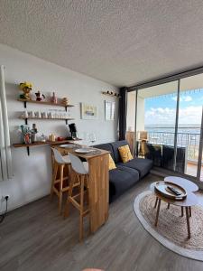 a living room with a couch and a table at Duplex vue mer et accès plage in Arcachon