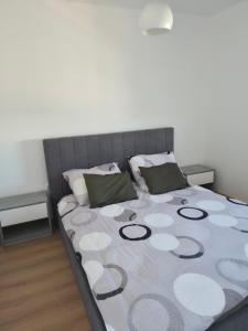 a bedroom with a large bed with a gray headboard at Apartman Milos in Modriča