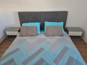 a bedroom with a large bed with two pillows at Apartman Milos in Modriča