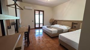 a bedroom with two beds and a kitchen with a counter at Hotel Oasi da Paolo in Castelluzzo