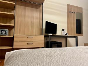 a bedroom with a bed and a desk with a television at Hotel Oasi da Paolo in Castelluzzo