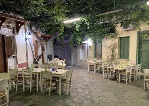 a dining room with tables and chairs and plants at Palokastro House Quiet Village Stay with Terrace in Samos
