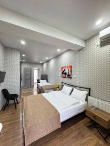 a bedroom with a large white bed and a desk at Airport Hotel Apartments in Tbilisi City