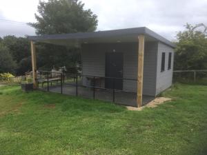 a small shed with a deck in a yard at Rexes Hollow Camping in Yeovil Junction