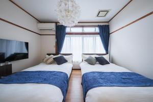 two beds in a room with a window at KEI HOUSE Yamato 202 in Yamato