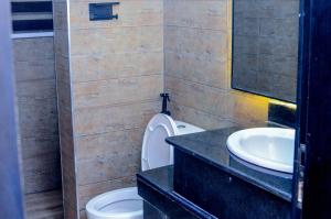 a bathroom with a toilet and a sink at Henry George Hotel Ltd in Idimu